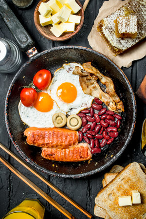 Traditional English Breakfast with orange juice. On black rustic background.の写真素材