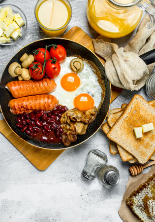 English breakfast. A variety of snacks with orange juice. On a rustic background.の写真素材