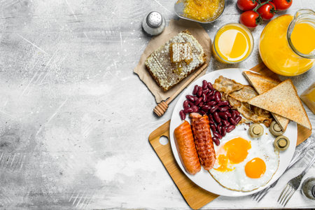 English breakfast. A variety of snacks with orange juice. On a rustic background.の写真素材