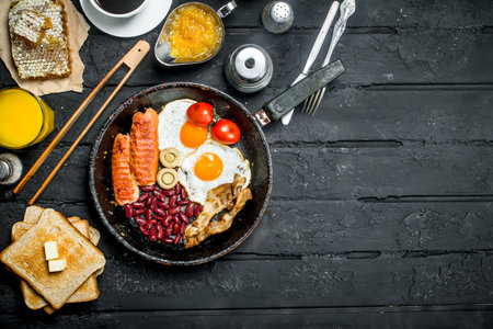 Traditional English Breakfast with orange juice. On black rustic background.の写真素材