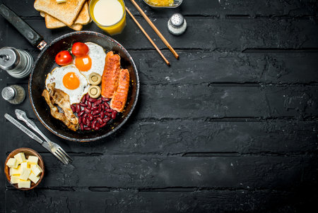 Traditional English Breakfast with orange juice. On black rustic background.の写真素材