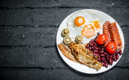 Traditional English Breakfast on a plate. On black rustic background.の写真素材