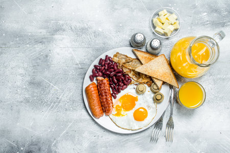 English breakfast. A variety of snacks with orange juice. On a rustic background.の写真素材