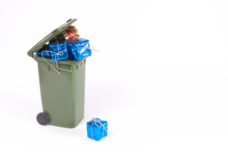 recycling bin full of christmas packages on white background