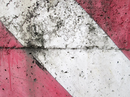 Diagonal red-white paint pattern on a rough textured cement の写真素材