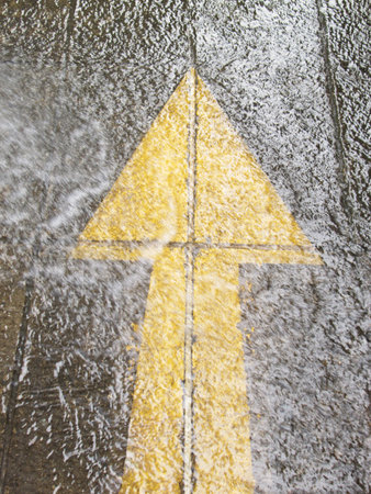 Yellow arrow on a wet road
