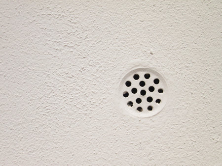 Drain cap on a white wallの写真素材