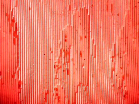 Red ribbed scratchy plastic as a backgroundの写真素材