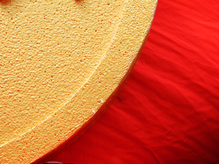 Gold plastic foam texture with red fabric clothの写真素材