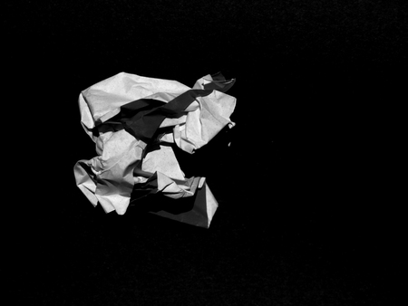 Crumpled paper ball on black backgroundの写真素材