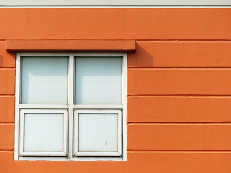 Window with frame on orange wallの写真素材