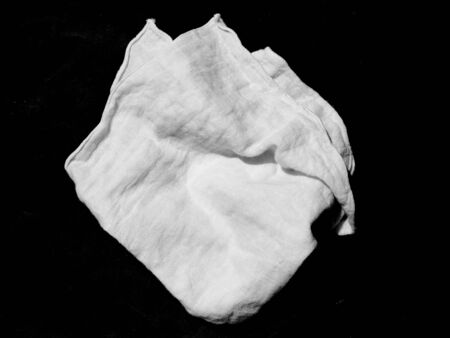 Crumpled white fabric cloth on black backgroundの写真素材