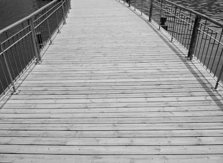 Wooden platform with an iron railing above the riverの写真素材