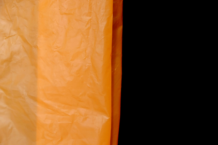 orange plastic bag on black backgroundの写真素材