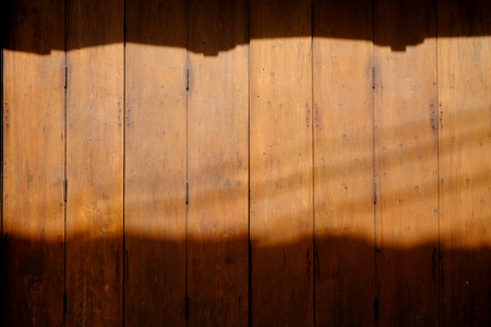 The Thai style vintage wooden door with light and shadow