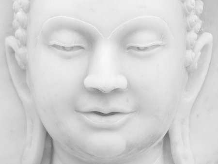 Closeup of the face of a white Buddha statueの写真素材