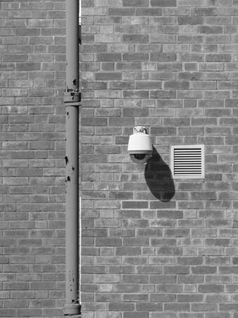 black and white security camera on the brick wall