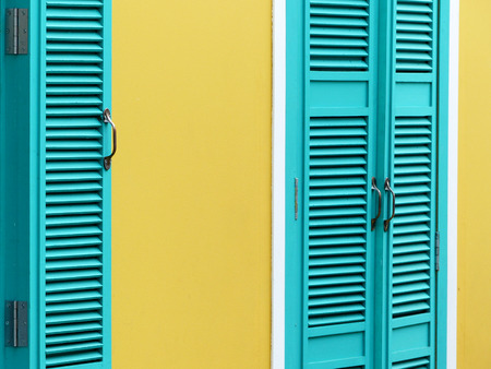 blue wood window on yellow wall