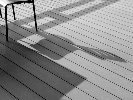 black and white chair and table on floor indoor with light and shadowの写真素材