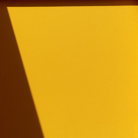 yellow wall with shadowの写真素材
