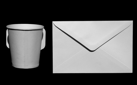 white paper cup and white envelope on black backgroundの写真素材