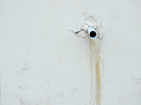 water pipe on old white wall with stainの写真素材