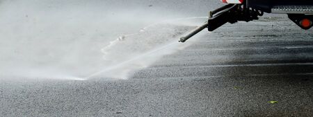 Cleaning car spray water on asphalt roadの写真素材