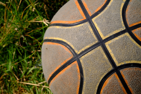 old basketball on green grass lawnの写真素材