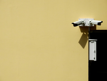 closed circuit camera on yellow wall backgroundの写真素材