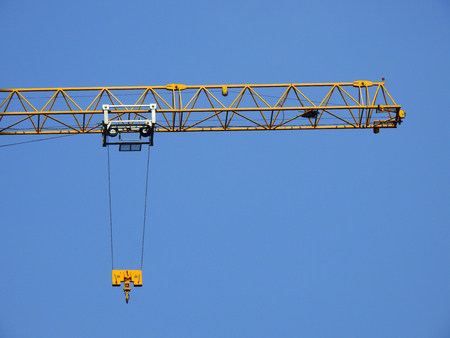 yellow crane and blue sky on building siteの写真素材