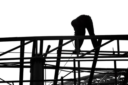 Silhouette labor working on building structure in construction siteの写真素材