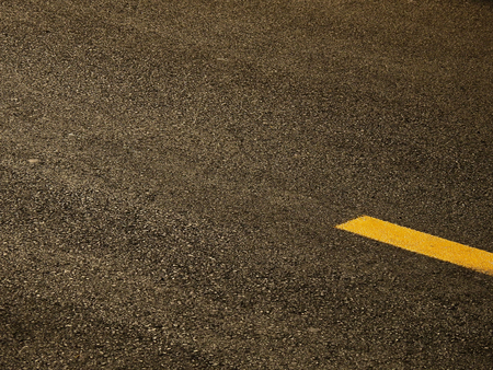 asphalt road with yellow line textureの写真素材