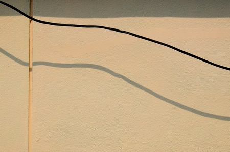 wire cable on brown wall with shadow minimalism styleの写真素材