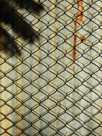 wire mesh of fence with zinc backgroundの写真素材