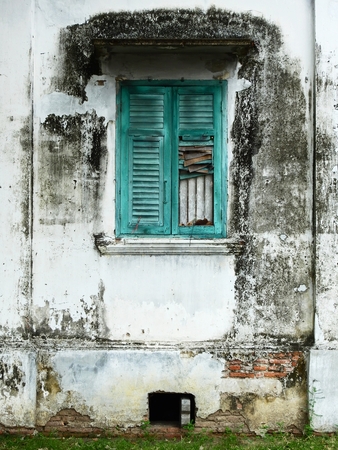 blue wood window close on dirty wall with moldの写真素材