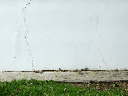 aged street wall with grass lawnの写真素材