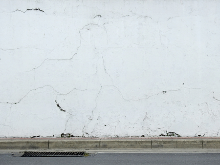 old white street wall with roadの写真素材