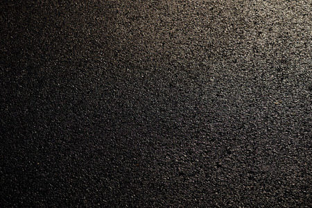 wet asphalt road with sunlight textureの写真素材