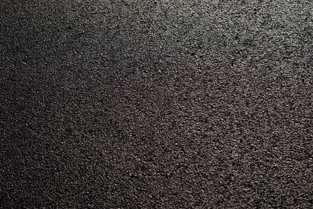 wet asphalt road with sunny textureの写真素材