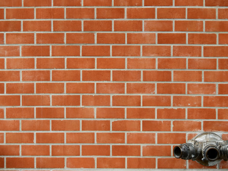 aged street brick wall with valve of fire hydrantの写真素材