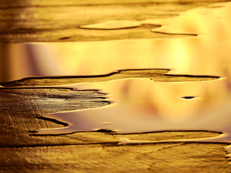 wet floor with golden water reflectionの写真素材