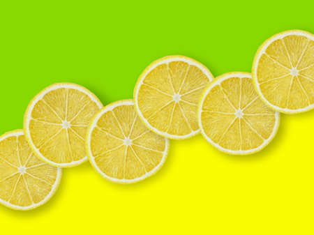 Creative look of lined lemon slices on a yellow-green background. Minimal summer time concept.