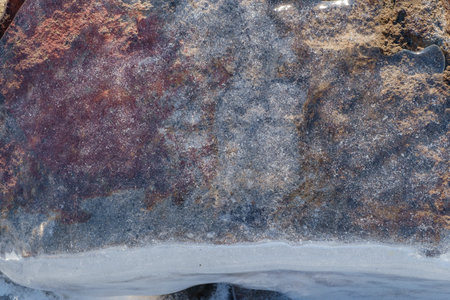 Stone covered with transparent ice with air bubbles. Ice texture. Selective focus.の写真素材