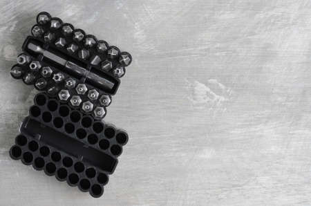 Screwdriver bits for various standards in a convenient package on a gray concrete background.の写真素材