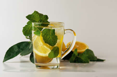 A glass glass of water with lemon slices, mint leaves and ice cubes. Non-alcoholic chilled drinkの写真素材