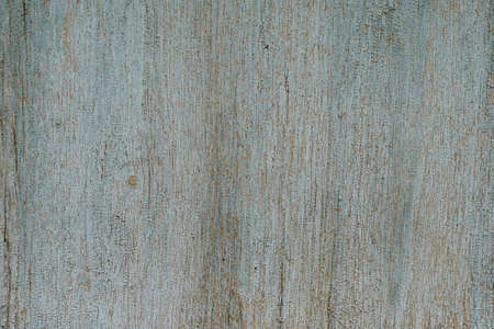 The old wooden surface is covered with light blue faded paint, finely cracked from old age. Texture,...