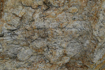 The texture of yellow-gray rock is rich in iron, giving a hint of rust. Background.