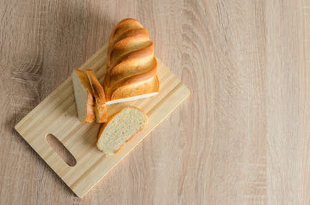 Sliced bread made of high-quality white flour on a cutting wooden board. Selective focus.