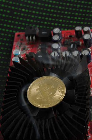 A bitcoin gold coin on a cooling fan in smoke. Selective focus.の写真素材