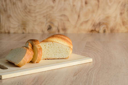 Sliced bread made of high-quality white flour on a cutting wooden board. Selective focus.の写真素材